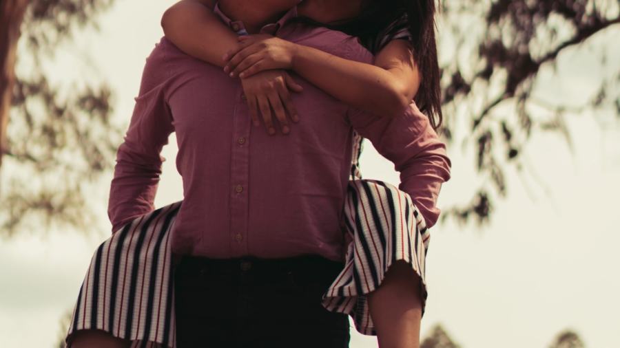 kaksi ihmistä toinen on reppuselässä