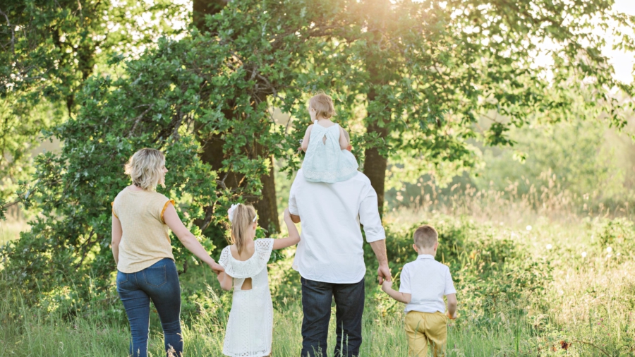 kaksi aikuista ja kolme lasta kävelemässä