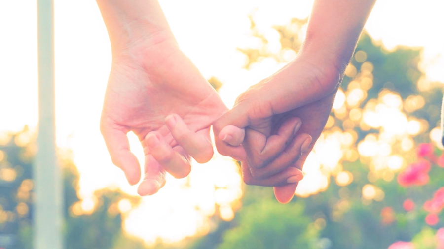 kaksi ihmistä käsi kädessä