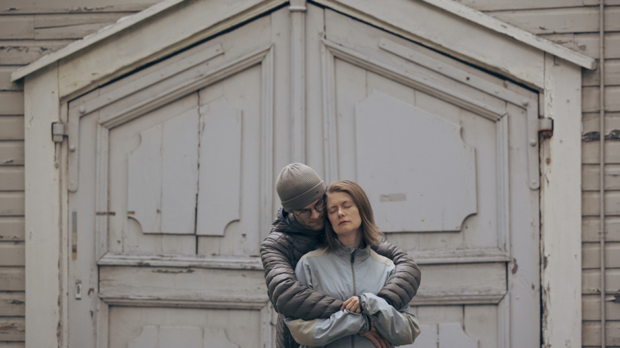 Pari halaamassa seinän edessä