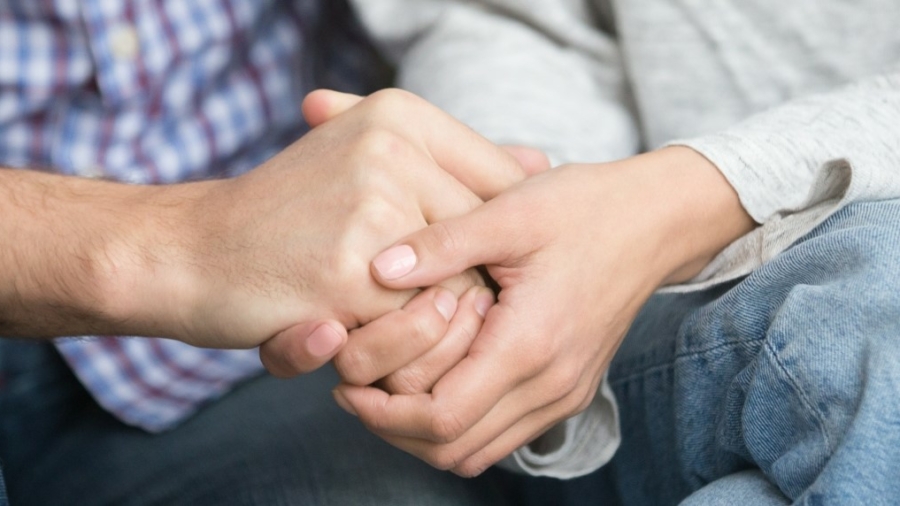 Kaksi kättä pitelemässä toisiaan